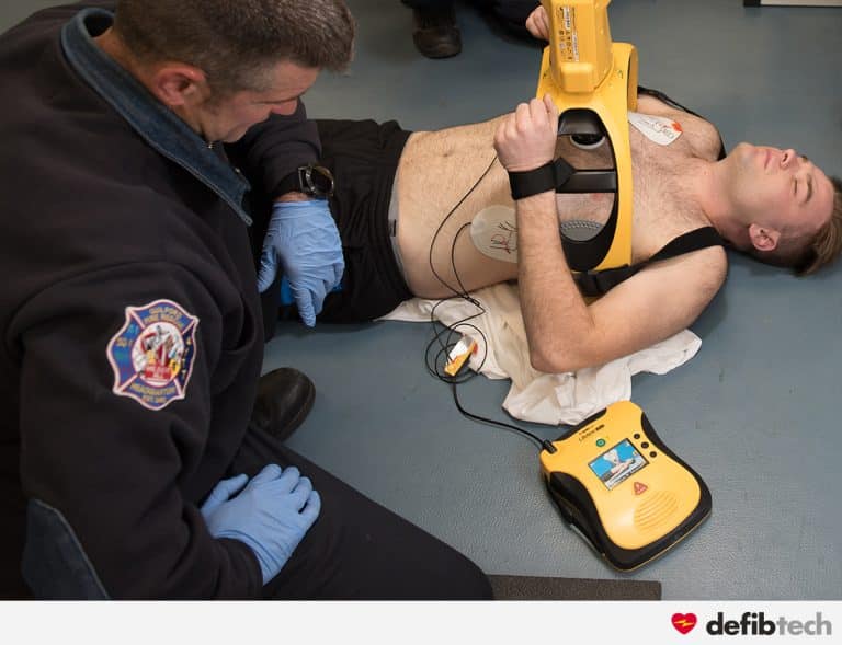 secouriste utilisant un défibrillateur lifeline view avec le lifeline arm sur un patient en arret cardiaque