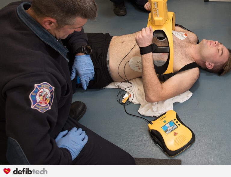 Secouriste intervenant sur un patient en arrêt cardiorespiratoire avec un défibrillateur lifeline View et le Lifeline Arm pour automatiser le massage cardiaque.